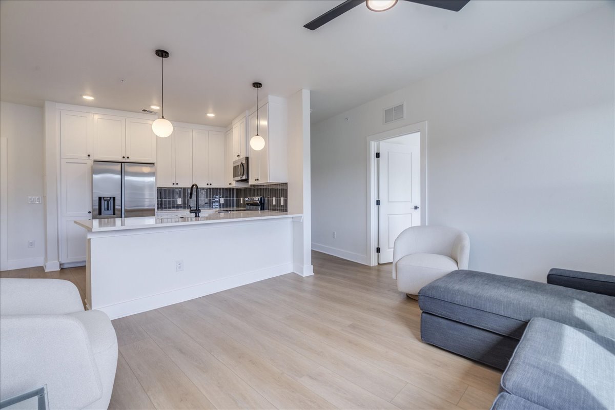 3000 Duval Street, Unit 203 Austin, TX 78705 - Photo 6 of 27 a living room with kitchen island furniture and a chandelier