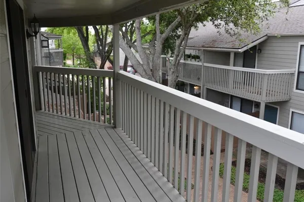 a view of an empty room with wooden floor and a fireplace