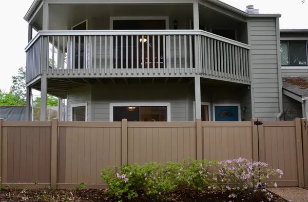 a view of a house with a window and wooden fence