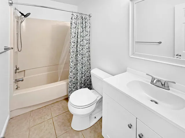 an empty room with a ceiling fan and carpet