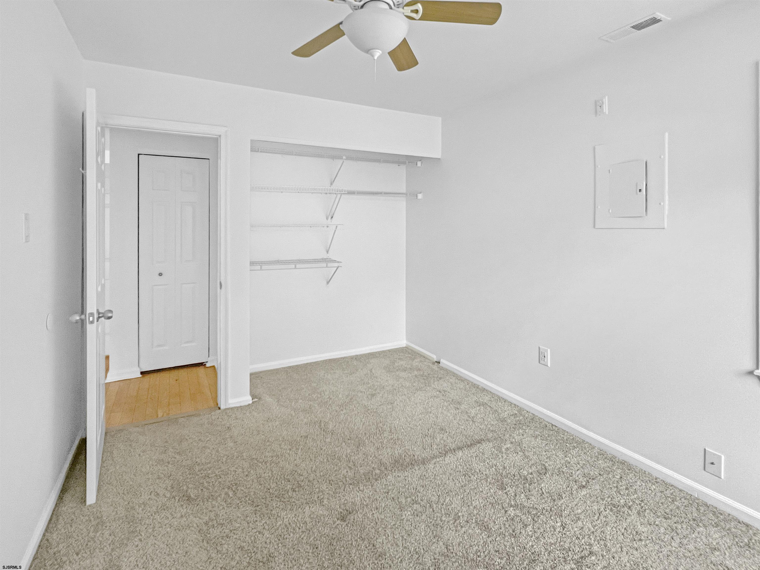 168 Westchester Drive, Unit 168 Little Egg Harbor, NJ 08087 - Photo 19 of 21 an empty room with a ceiling fan and carpet