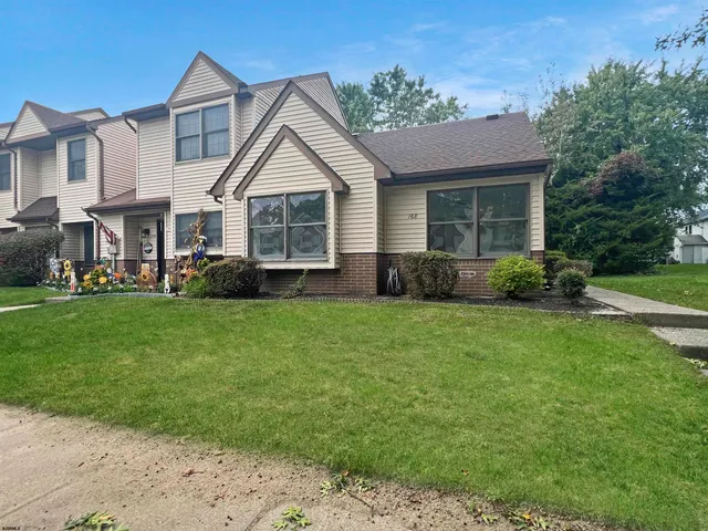 a view of a house with a yard and potted plants