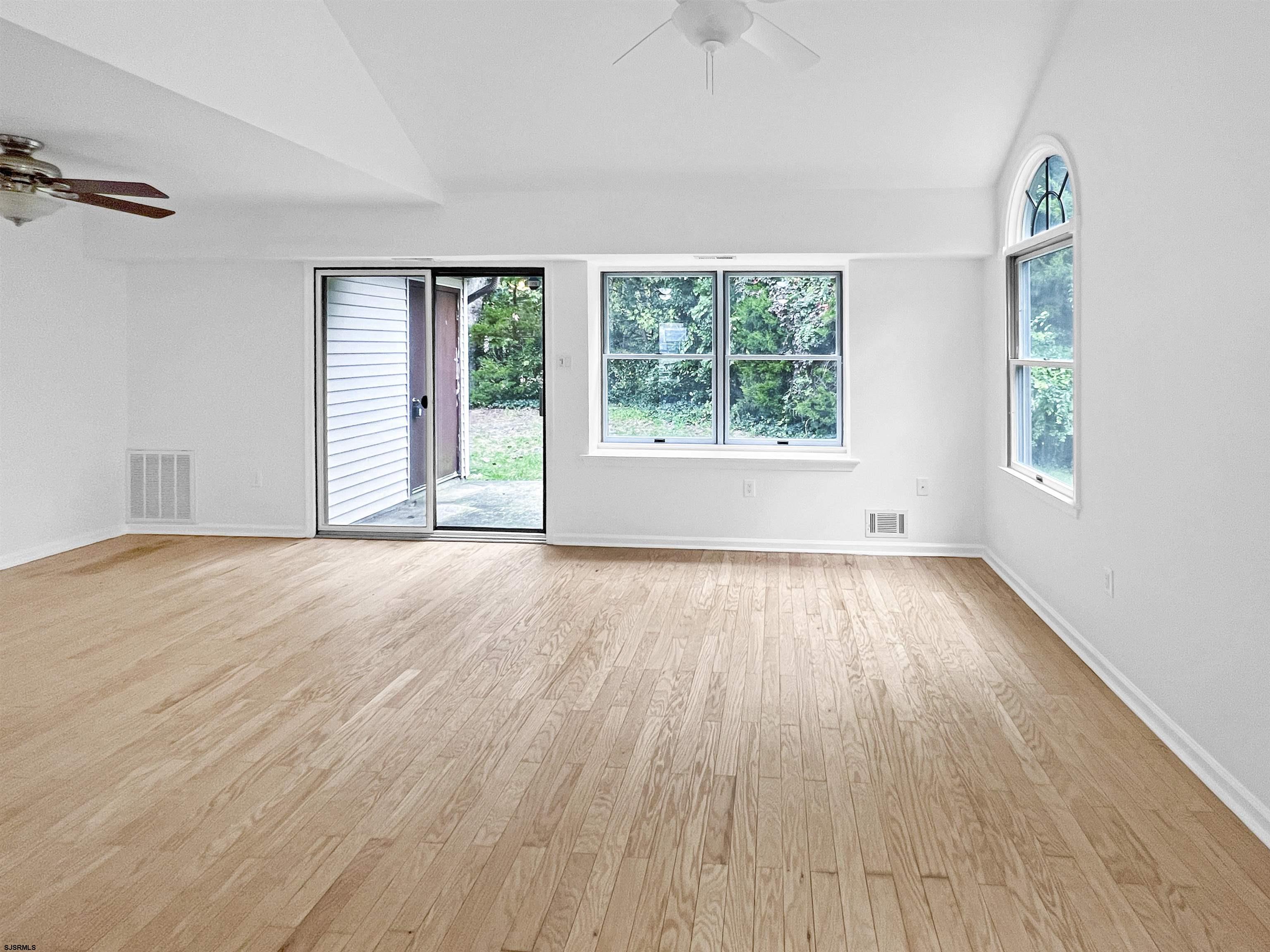 168 Westchester Drive, Unit 168 Little Egg Harbor, NJ 08087 - Photo 7 of 21 an empty room with wooden floor and windows