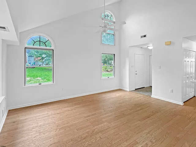a view of a kitchen with a sink and dishwasher with wooden floor