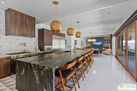 a view of swimming pool with outdoor seating and house in the background