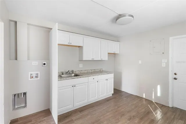 a kitchen with granite countertop a sink and cabinets