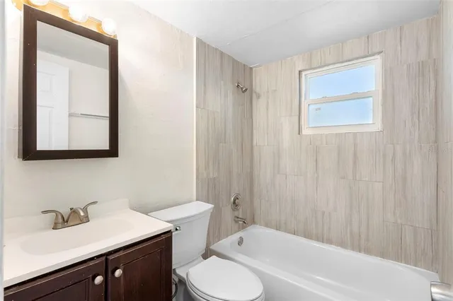 a bathroom with a sink vanity mirror and toilet