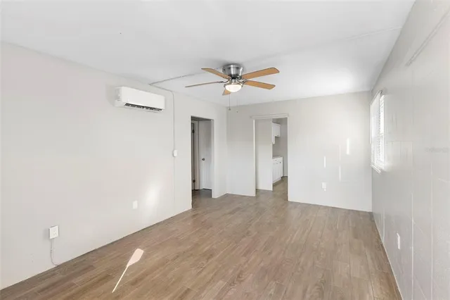 a view of a big room with wooden floor and a ceiling fan