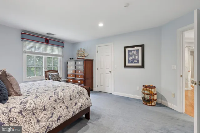 a view of a white house with a big yard and large trees