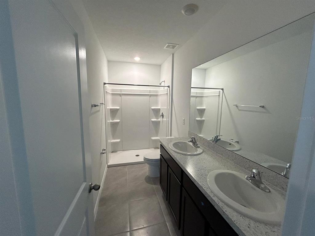 16620 Grotto Steam Place Wimauma, FL 33598 - Photo 11 of 19 a bathroom with a double vanity sink mirror double and shower