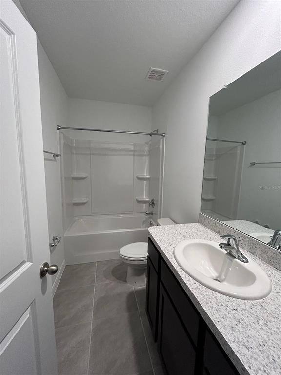 16620 Grotto Steam Place Wimauma, FL 33598 - Photo 12 of 19 a bathroom with a granite countertop sink a toilet and shower