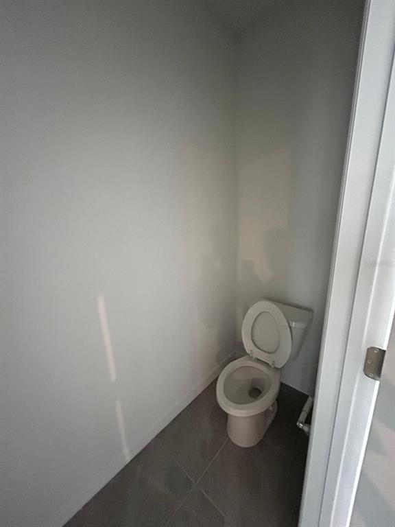 16620 Grotto Steam Place Wimauma, FL 33598 - Photo 13 of 19 a white toilet sitting in a small bathroom
