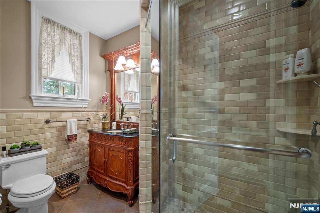 29 North Church Road Saddle River, NJ 07458 - Photo 19 of 42 a bathroom with a granite countertop sink a toilet and shower