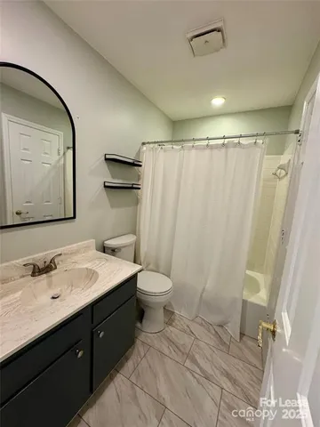 a bathroom with a double vanity sink toilet and shower