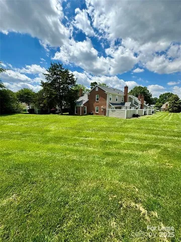 a view of a big yard with plants and large trees