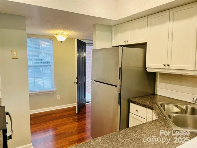 a kitchen with stainless steel appliances granite countertop a refrigerator and a sink