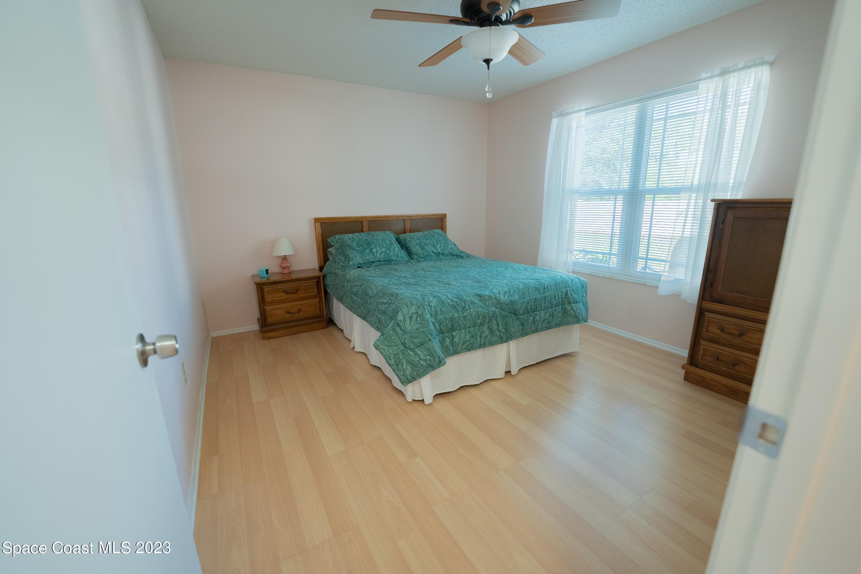 920 Gables Way Melbourne, FL 32940 - Photo 15 of 24 a room with a bed and a flat tv screen on a dresser