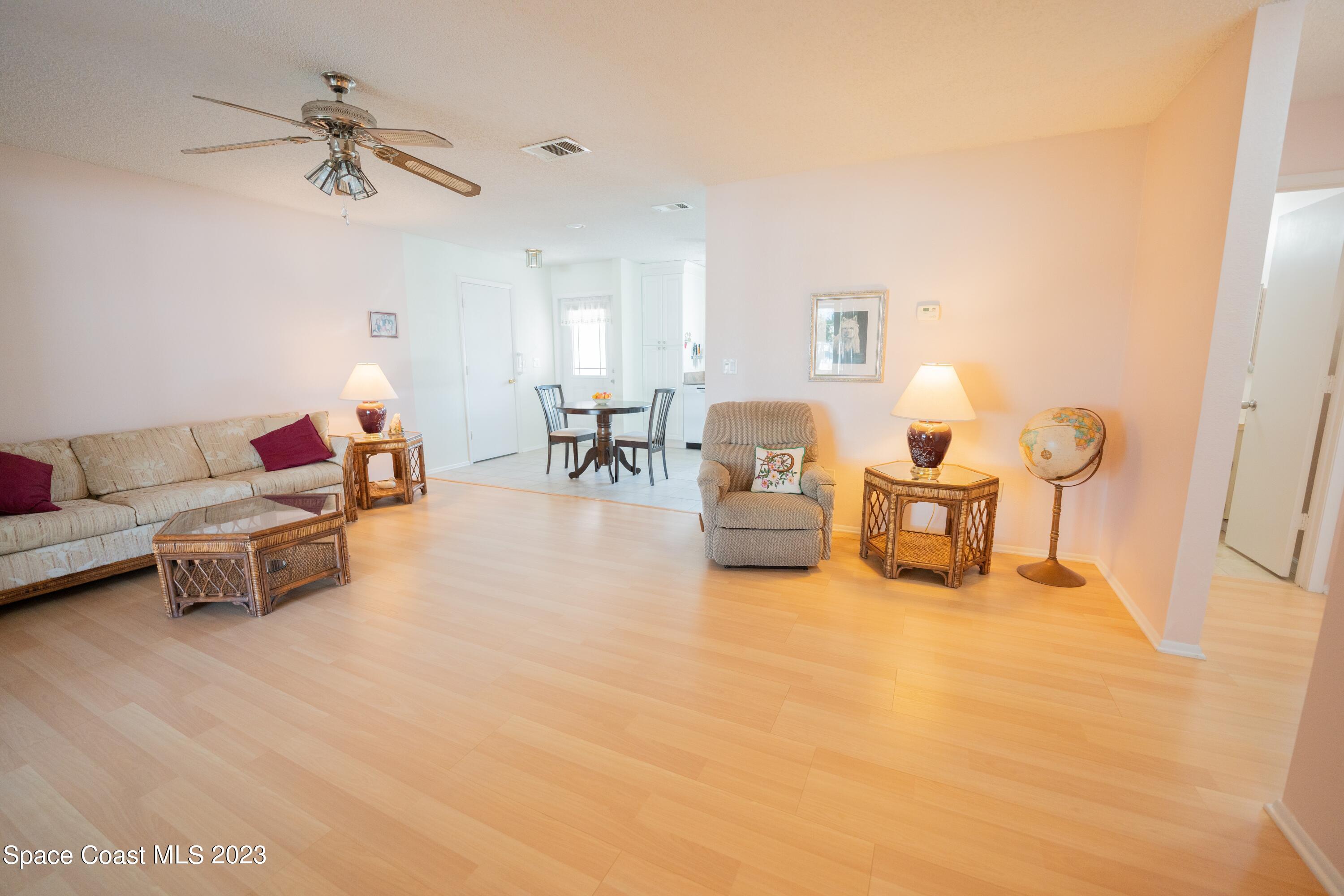 920 Gables Way Melbourne, FL 32940 - Photo 22 of 24 a living room with furniture and a chandelier