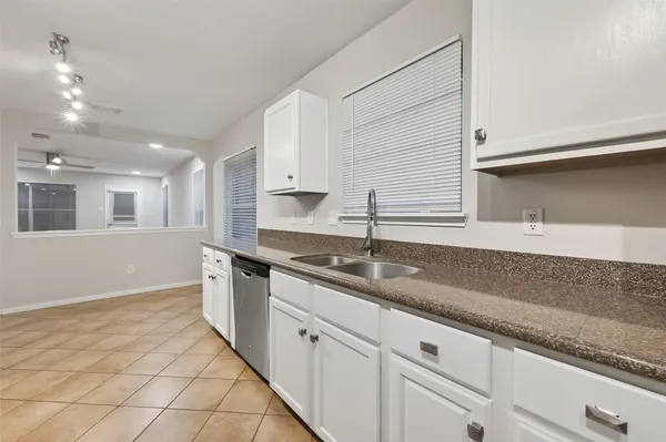 a kitchen with granite countertop a sink a stove and cabinets