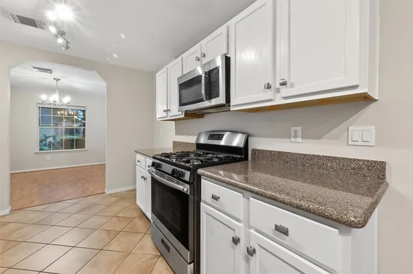 a kitchen with stainless steel appliances granite countertop a sink and a stove