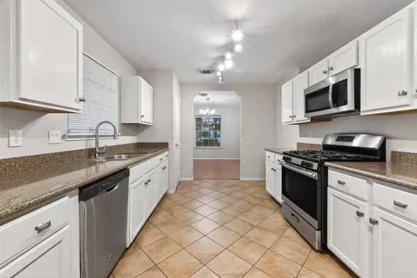 a large kitchen with stainless steel appliances granite countertop a sink and a stove