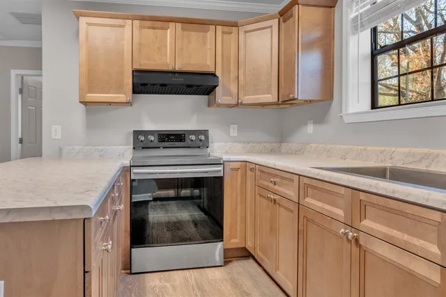 a kitchen with granite countertop a stove a sink and a microwave