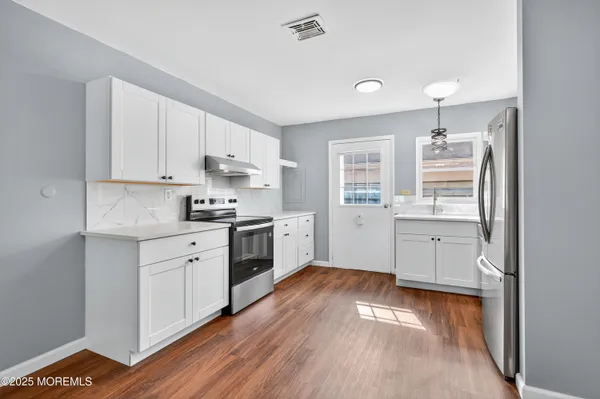 a kitchen with granite countertop white cabinets and white appliances