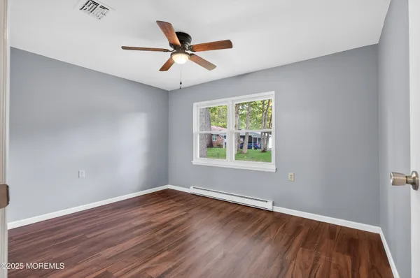 wooden floor in an empty room with a window