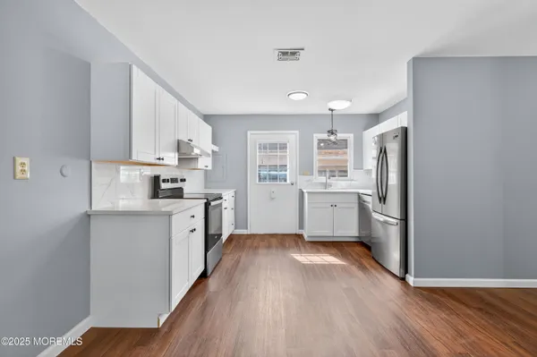 a kitchen with stainless steel appliances a refrigerator sink and cabinets