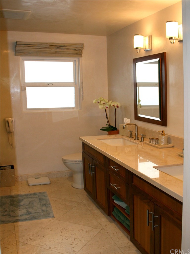 614 The Strand Manhattan Beach, CA 90266 - Photo 26 of 41 a bathroom with a granite countertop sink toilet and mirror