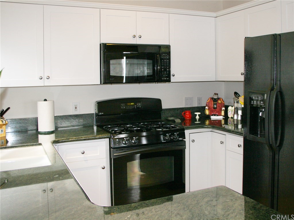 614 The Strand Manhattan Beach, CA 90266 - Photo 35 of 41 a kitchen with stainless steel appliances granite countertop a stove and a refrigerator