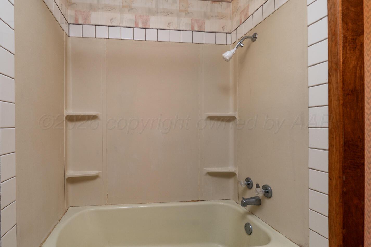 300 Mccarthy Street Borger, TX 79007 - Photo 22 of 31 a bathroom with a shower and a bath tub