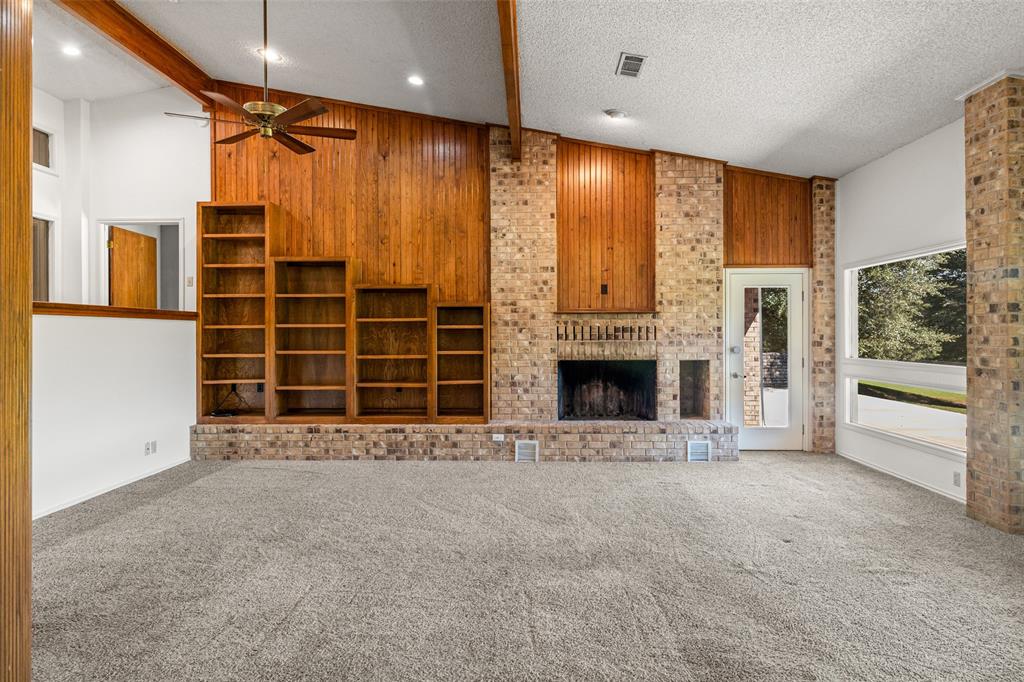 7508 Ravenswood Road Granbury, TX 76049 - Photo 14 of 40 a view of an empty room with a fireplace and a window