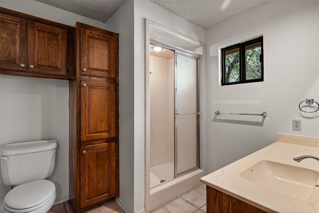7508 Ravenswood Road Granbury, TX 76049 - Photo 23 of 40 a bathroom with a sink a toilet and shower
