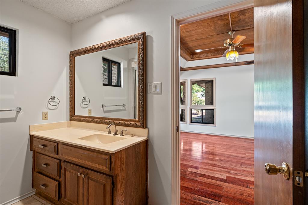 7508 Ravenswood Road Granbury, TX 76049 - Photo 24 of 40 a bathroom with a sink a mirror and a vanity