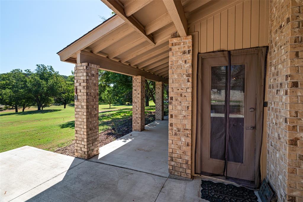 7508 Ravenswood Road Granbury, TX 76049 - Photo 37 of 40 a view of a entrance gate of the house and trees