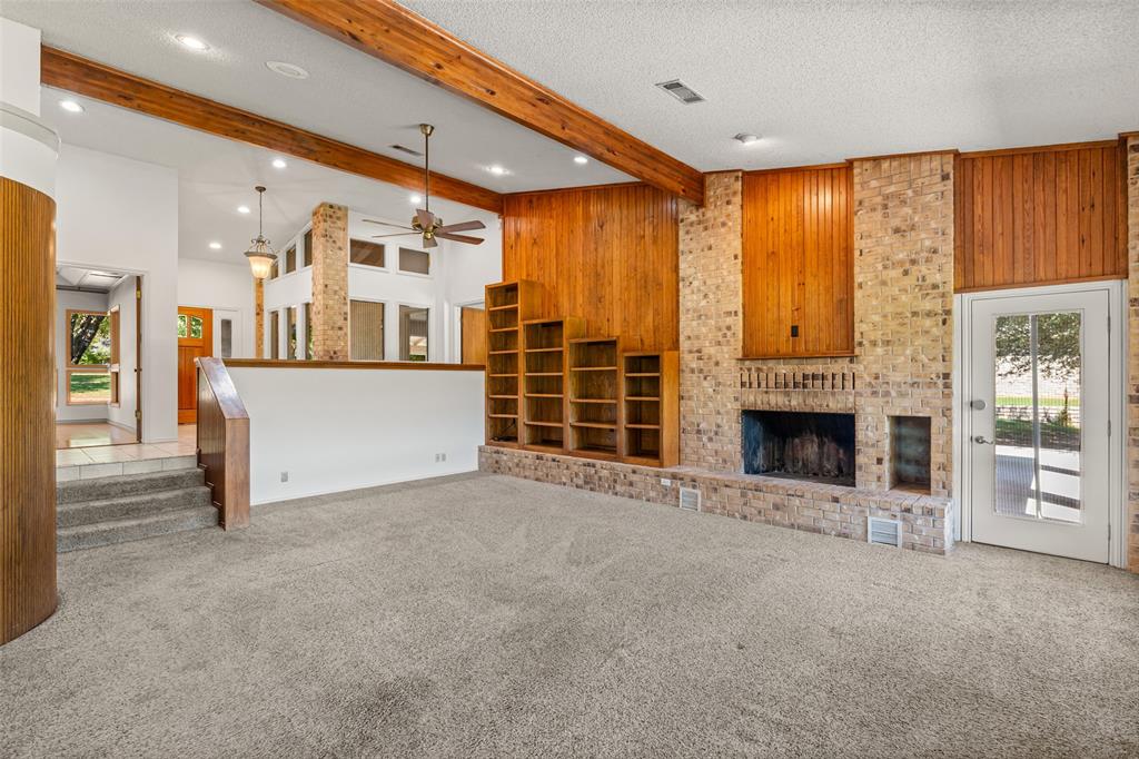 7508 Ravenswood Road Granbury, TX 76049 - Photo 9 of 40 a view of a livingroom with an empty space and a fireplace