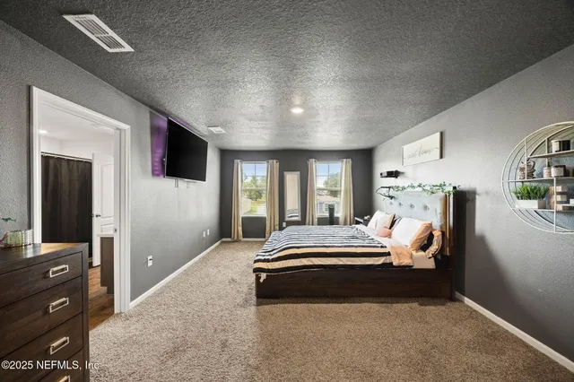 a spacious bedroom with a bed and wooden floor