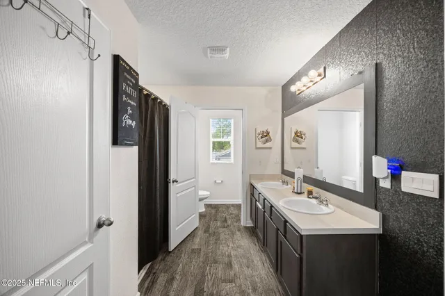 a bathroom with a sink and mirror with toilet