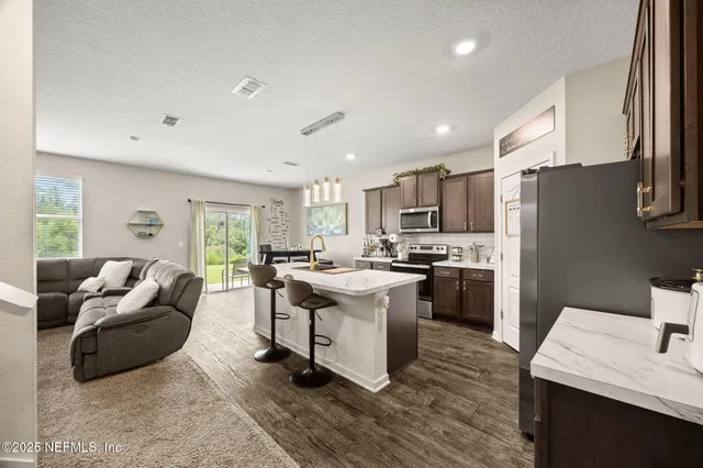 a kitchen with a sink dishwasher a stove and a refrigerator with wooden floor