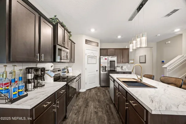 a kitchen with stainless steel appliances granite countertop a sink stove and refrigerator