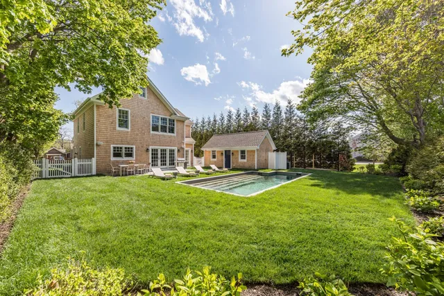 a view of a house with a big yard plants and large trees