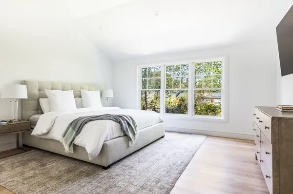 a spacious bedroom with a bed and a large window