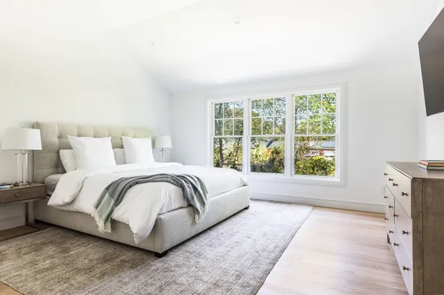 a spacious bedroom with a bed and a large window