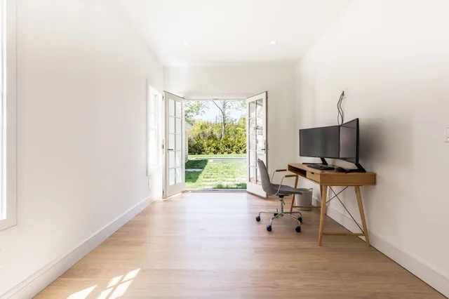 a view of a workspace with furniture and a window
