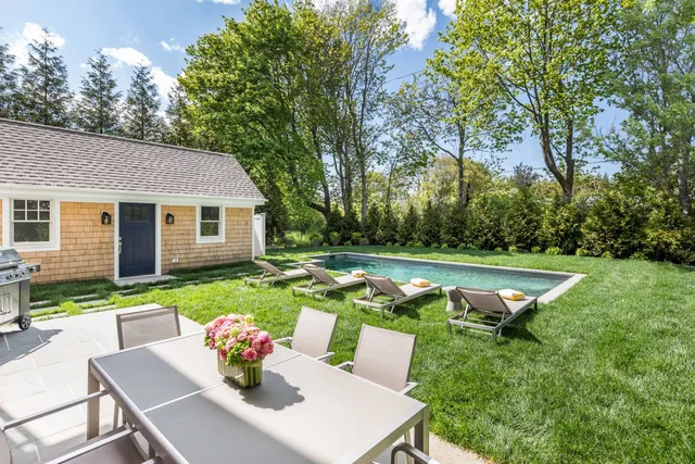 a view of a house with backyard and a patio