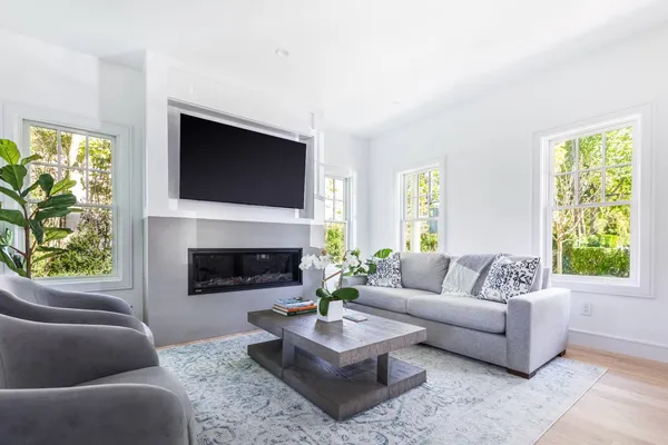 a living room with furniture a flat screen tv and a fireplace