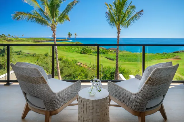 a view of a patio with couches chairs under an umbrella