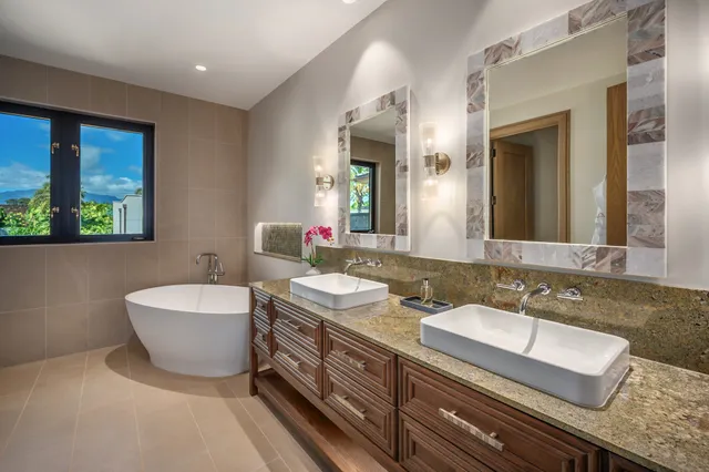a bathroom with a double vanity sink a mirror and a bathtub