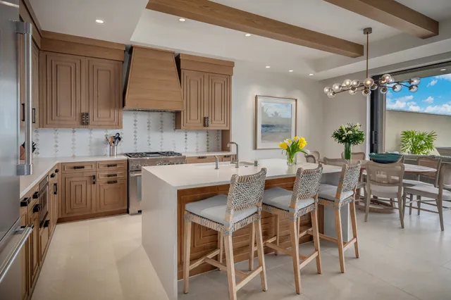 a kitchen with a sink window and chairs